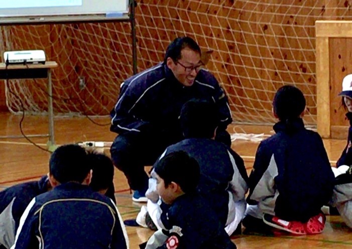 Photo of teaching a baseball team member at a Deaf school