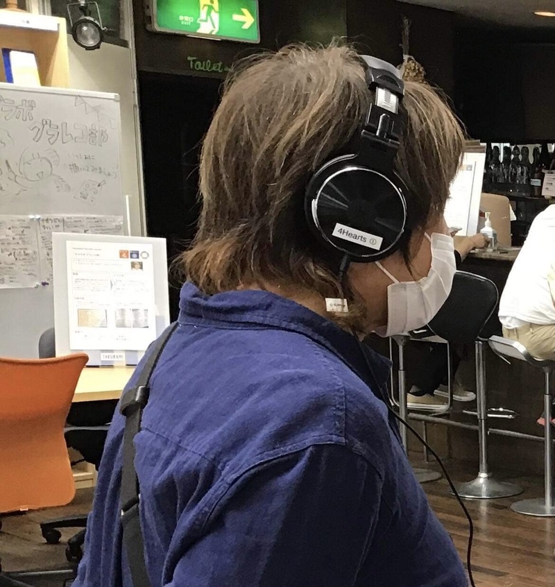 A photo of a person wearing headphones at a cafe and ordering inaudibly